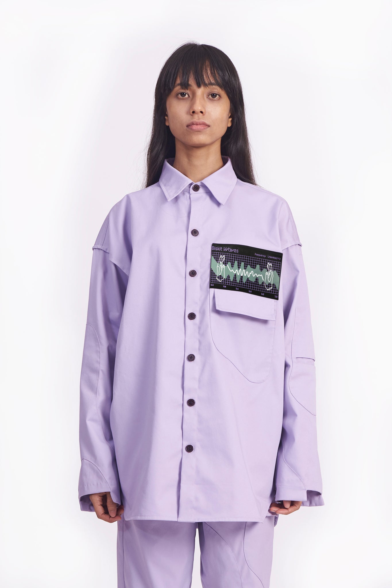 This medium weight lavender shirt / over shirt features front black natural corozo buttons, a flap pocket, our ‘Biskit waves Frequency’ printed patch, pocket on the left sleeve and irregular shapes patched on the front, back and sleeves.